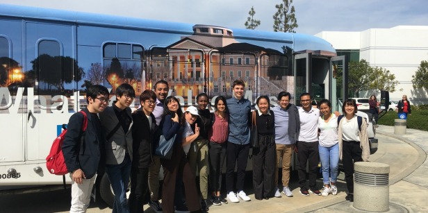 A group of students pose in front of the Soka University bus