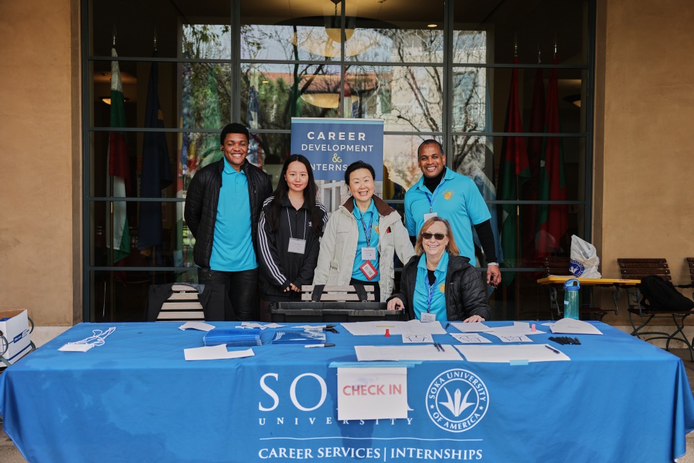 The Career Development and Internships Office team poses for a photo at their table outside the Bistro