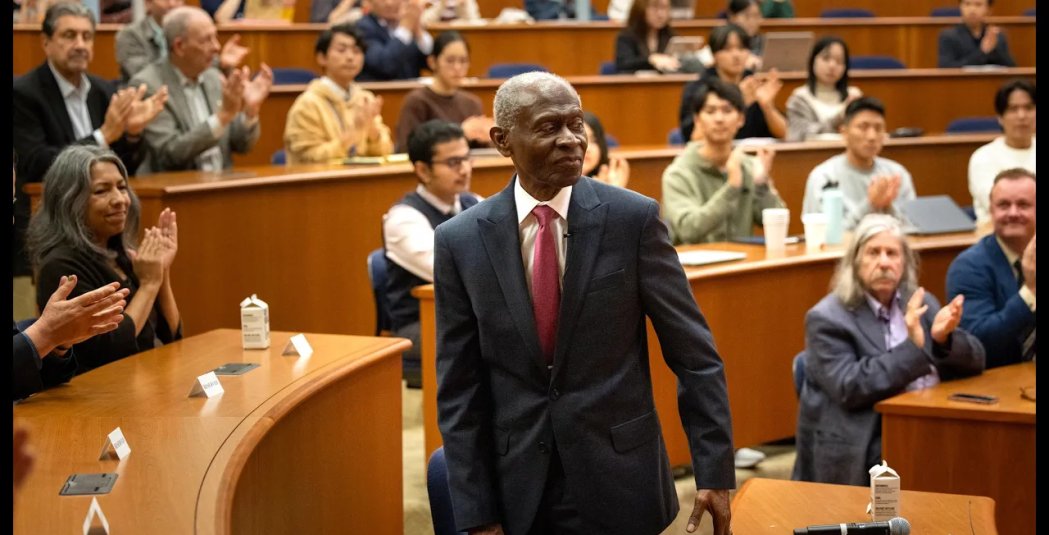 Dr. Lawrence E. Carter, Sr. walks up to the podium in a crowded auditorium as the crowd applauds.