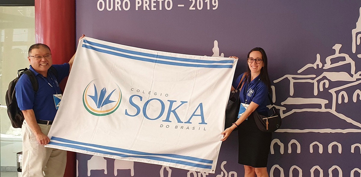 Two teachers holding Soka flag