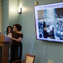 Two female speakers read from a podium during a community dialogue about Dr. King’s final speech, "I’ve Been to the Mountaintop."