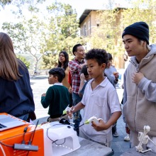 An SUA student shows a young boy a laparoscopic technique