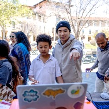 An SUA student helps a young boy during a youth health advocacy event at SUA