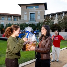 Students hold a gift basket after winning a raffle