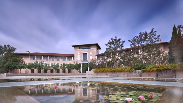 Lily ponds in the foreground of Ikeda Library with blue sky overhead