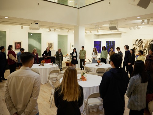 Members of the SUA community stand in a circle during the 2023 Thankstaking event held in Founders Gallery