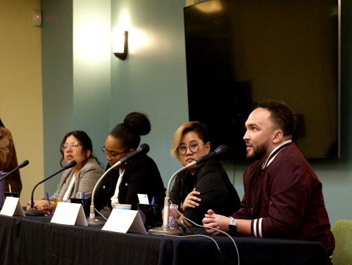 SUA alumni sit at a table with microphones to answer questions during a Career Night event