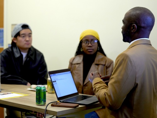 Two SUA students listen intently to a speaker during Career Night