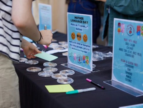 An SUA student prepares to write on a notecard during a tabling event