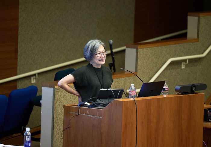 A female speaker presents during the symposium