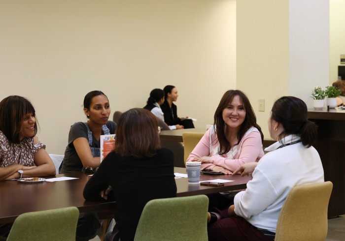 A group of women sit at a table and have a discussion during Connecting with Colleagues