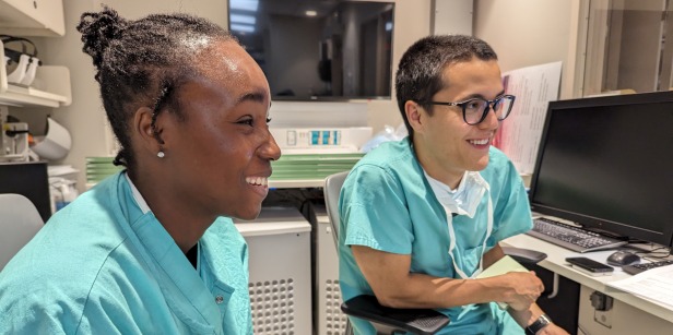 Two students wearing teal scrubs review imaging during their neurosurgery preceptorship in Summer 2023.