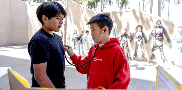 Kids listen to eachothers' hearts using a stethoscope