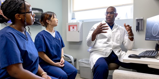 Dr. Vernard S. Fennell, MD MSc speaks to two SUA students during their neurosurgery clinical and research preceptorship 