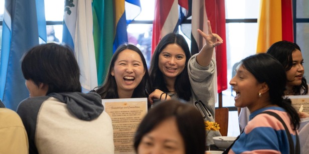 Two students smile at the camera amidst a crowd of people in the Bistro