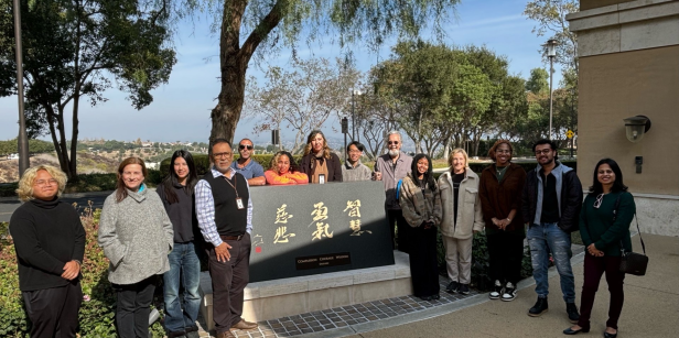 Writing Center staff gathered around a plaque titled "Wisdom, Courage, Compassion." 