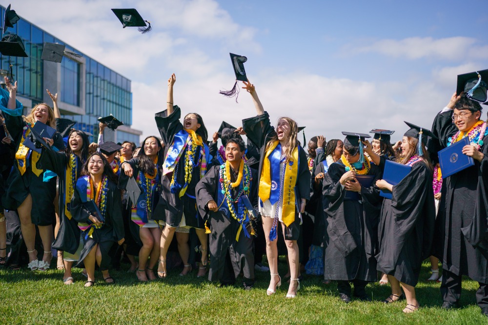 Soka graduates toss their caps in the air as they celebrate during Commencement Day 2024