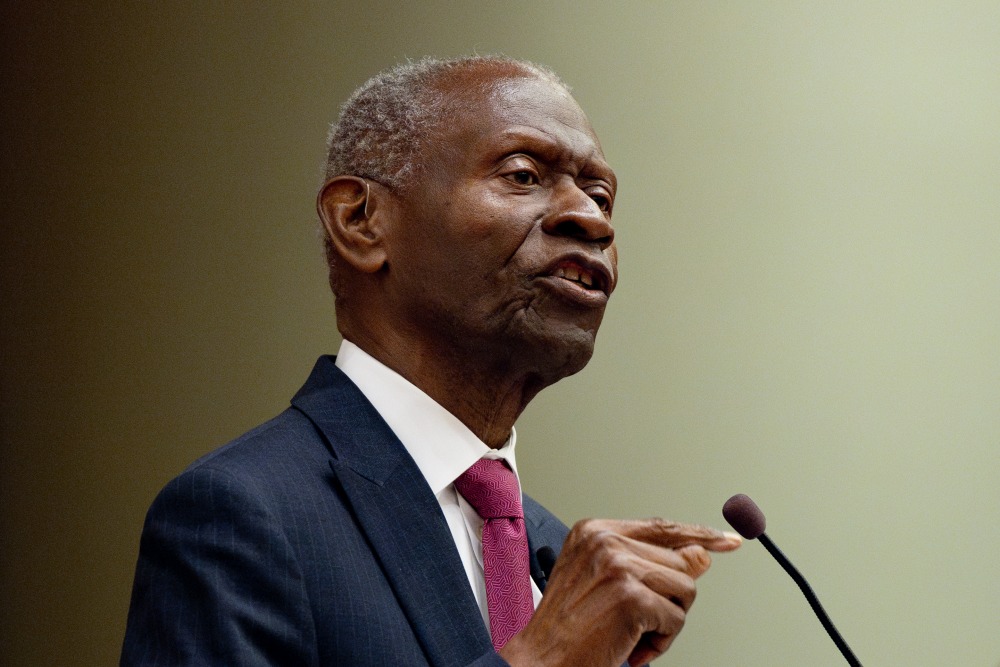 Dr. Lawrence E. Carter, Sr. gestures with his hands as he speaks at SUA