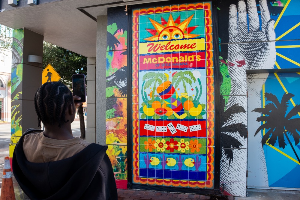 Emmanuel Tetteh ’27 takes a photo of a vibrant mural in Little Havana, Miami, as part of his photography project for Cardona’s Learning Cluster.