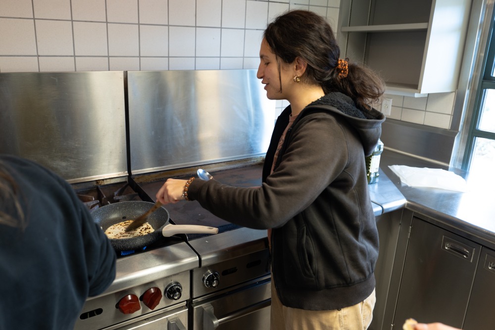 Mareva Dijoux ’26 cooks a tortilla in a skillet during the cooking portion of Esiobu’s Learning Cluster on Indigenous food systems.