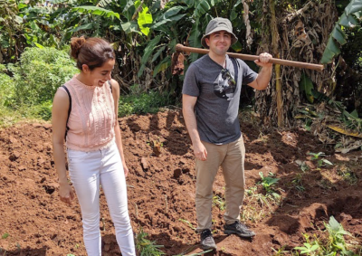 Nandini Puri ’14 stands with her husband and business partner, Andrew Bawdon on farmed soil.