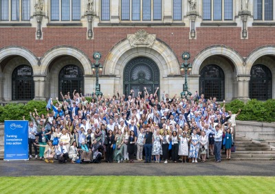 340 participants raise their arms and pose for a group photo during the 25th anniversary of Earth Charter event.