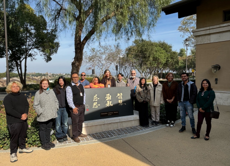 Writing Center staff gathered around a plaque titled "Wisdom, Courage, Compassion."