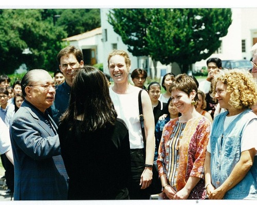 Ikeda speaks with a group of people on campus